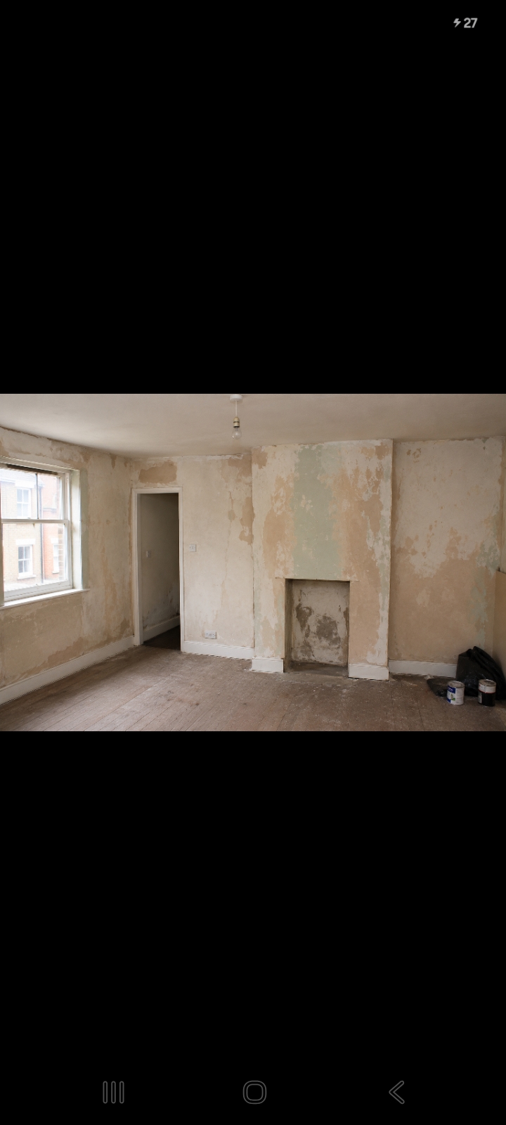 Bare patchy plaster walls before painting